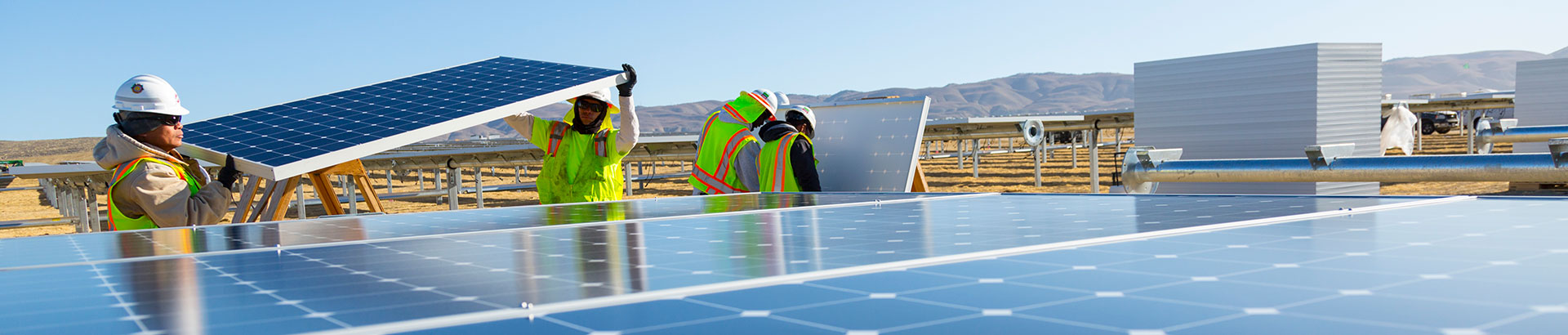 workers installing solar panels in a field